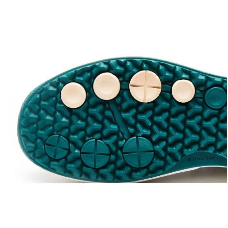 Close-up of a golf  shoe sole with textured pattern and metallic accents on a white background